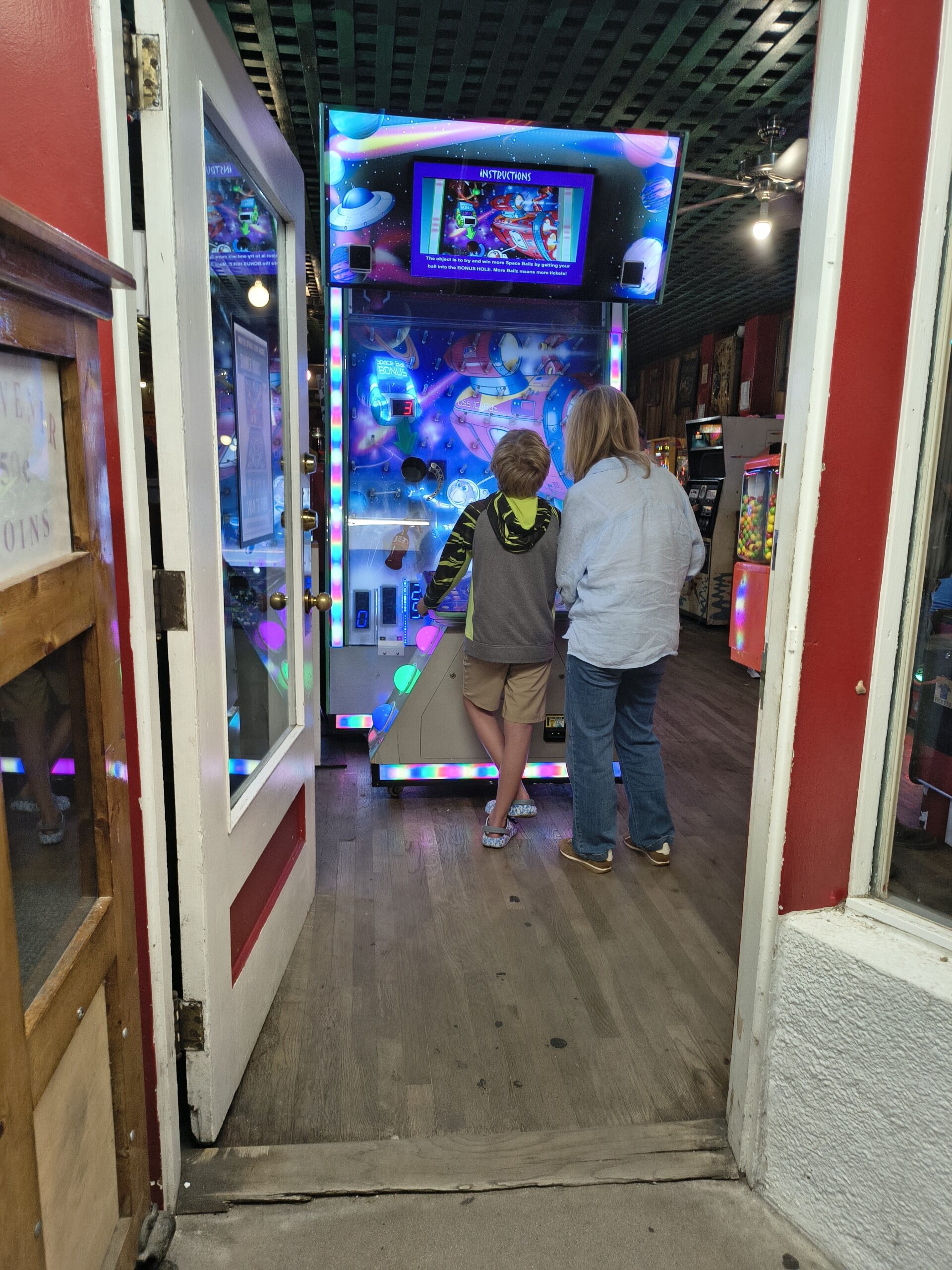 Family playing a space-themed arcade ball game at the Penny Arcade Manitou Springs
