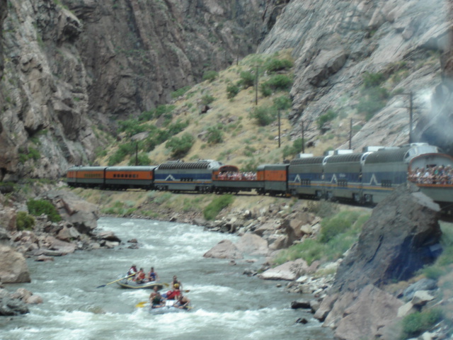 Royal Gorge Route Railroad train alongside rafters on the Arkansas River